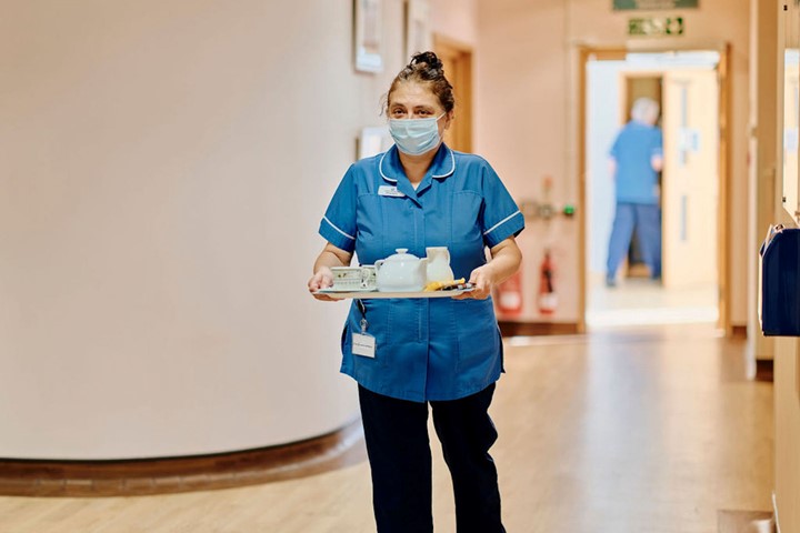 Image of health care assistant carrying tea tray 