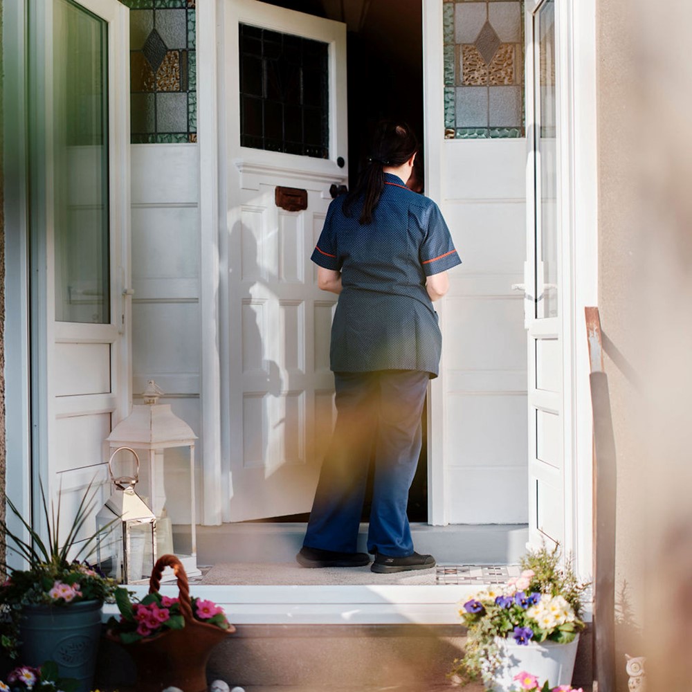 Image of community team nurse knocking on patients door 